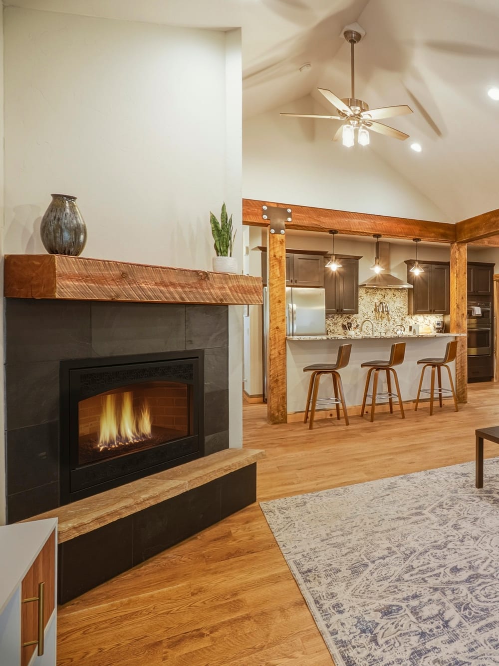 Warm mountain great room with a stone fireplace, reclaimed-wood beams, and an open kitchen, Pagosa Springs